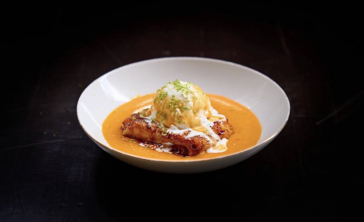 Caramelized brioche dessert with ice cream in an orange sauce
